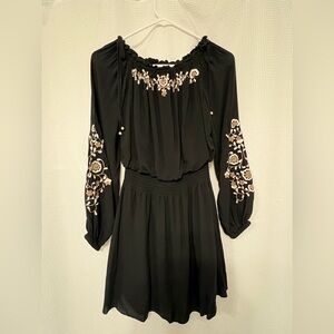 A black White House Black Market dress with embroidery accents in size XS